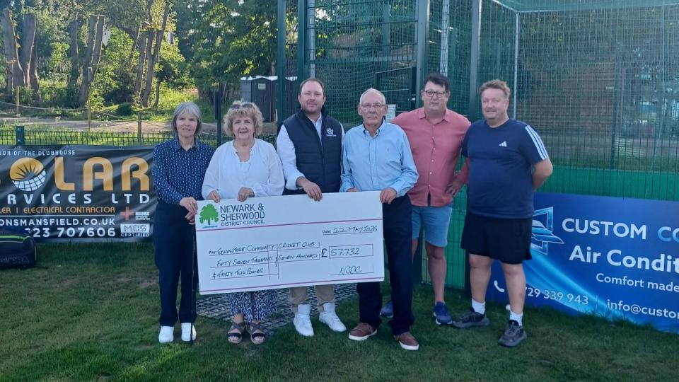 5 people stood in front of the new nets at Edwinstowe Cricket Club with a giant cheque for the funding